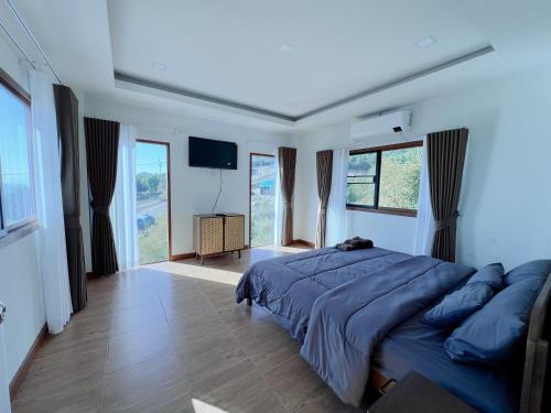 um quarto com uma cama grande com lençóis azuis e janelas em deep mountain view em Ko Larn