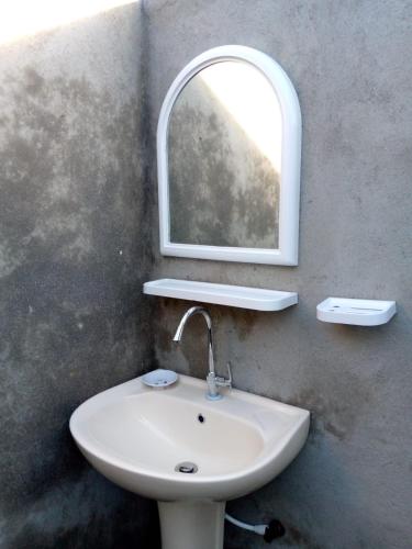 a bathroom with a sink and a mirror at Ethili Lake view & Safari Camp in Wellawaya