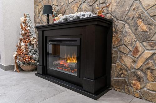 a fireplace against a stone wall with a fire in it at Willa Trawers in Zakopane