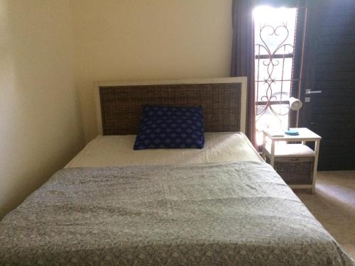 a bedroom with a bed with a blue pillow and a window at Simple apartment 1 in Seminyak