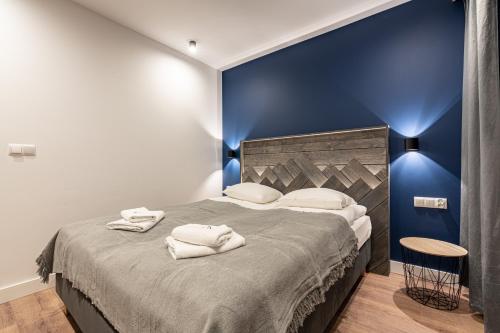 a bedroom with a large bed with a blue wall at Willa Trawers in Zakopane