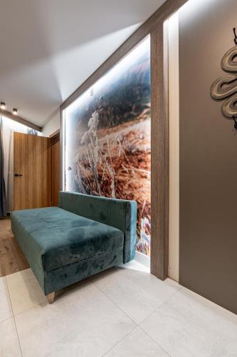 a room with a green bench in front of a painting at Willa Trawers in Zakopane