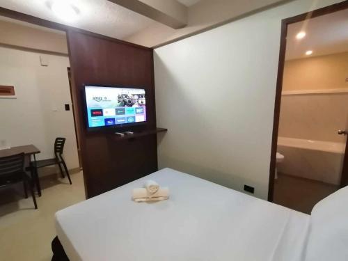 a room with a bed and a television in it at Sunny Day Residences Cainta in Cainta
