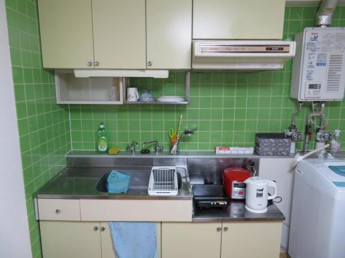 a small kitchen with a sink and green tiles at 札幌市中心部大通公園まで徒歩八分観光移動に便利なロケーションe1007#17 in Sapporo