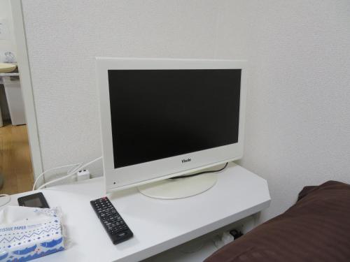 a computer monitor sitting on a desk with a remote control at 札幌市中心部大通公園まで徒歩八分観光移動に便利なロケーションe1007#17B in Sapporo