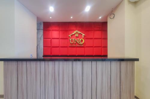 a red wall with a sign on top of a counter at RedDoorz Plus @ UNO Jalan Merak Samarinda in Samarinda