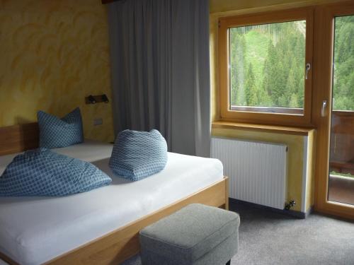 1 dormitorio con 1 cama con silla y ventana en Kreidl, en Tux