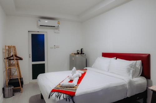 Amit Resort 51 Hua Hin في هوا هين: غرفة نوم بسرير ابيض عليها دبدوب