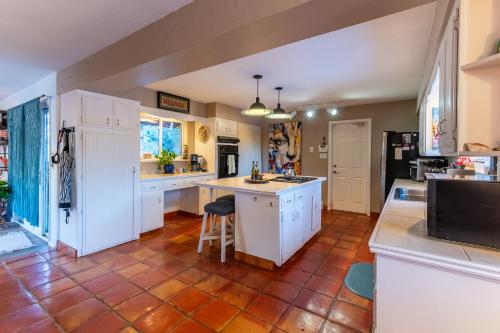 a kitchen with white cabinets and a tile floor at Winnemucca Heights in Cascade-Chipita Park