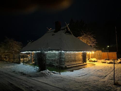 a house with a snow covered roof with lights at Pirtiņa in Ogre