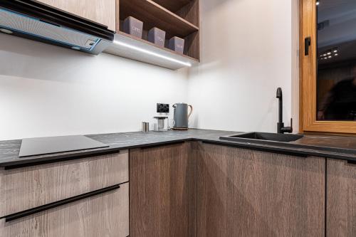 a kitchen with wooden cabinets and a sink at Willa Trawers in Zakopane