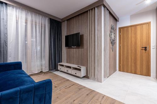a living room with a blue couch and a door at Willa Trawers in Zakopane