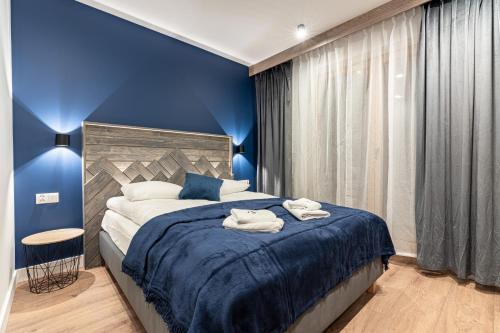a blue bedroom with a bed with towels on it at Willa Trawers in Zakopane