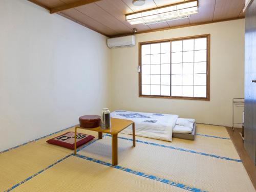 um quarto com uma cama e uma mesa em Fureaihouse Shiodu no Sato em Sado