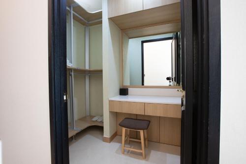 a bathroom with a sink and a stool next to a mirror at Union Hotel in Seoul