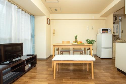 a living room with a table and a kitchen at 札幌市中心部大通公園まで徒歩十分観光移動に便利なロケーションh205#13B in Sapporo