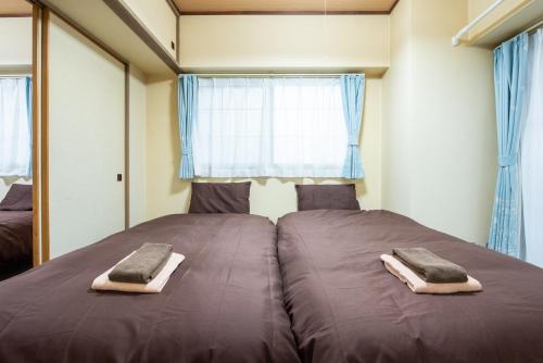 a large bed in a room with blue curtains at 札幌市中心部大通公園まで徒歩十分観光移動に便利なロケーションh205#13B in Sapporo