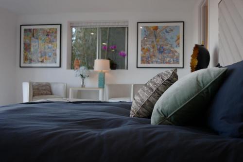 Skyline Serenity Luxe Suite-Private Room في لوس أنجلوس: سرير أزرق مع وسائد في غرفة النوم