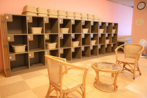a room with two chairs and a shelf with baskets at glampark Gekkabijin Nagano in Shimojo mura