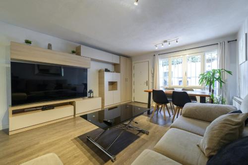 a living room with a couch and a tv and a table at Casa familiar Sabadell de 3 dormitorios junto metro Fuencarral in Madrid
