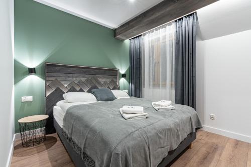 a bedroom with a large bed with two towels on it at Willa Trawers in Zakopane