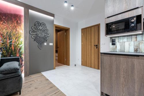 a living room with a kitchen with a microwave at Willa Trawers in Zakopane