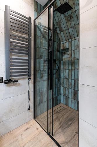 a shower with a glass door in a bathroom at Willa Trawers in Zakopane