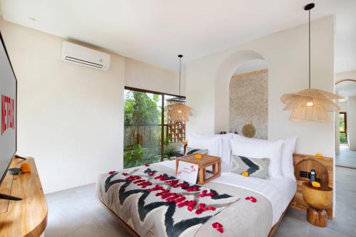 a bedroom with a large bed with red flowers on it at Suara Alam Hotel Ubud by Ini Vie Hospitality in Ubud