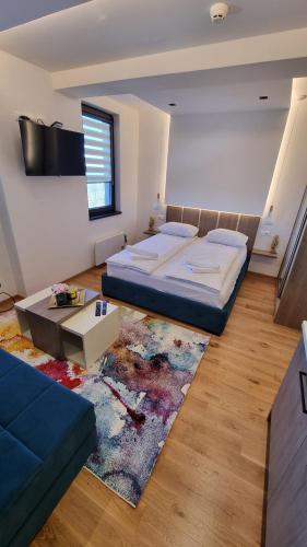 1 dormitorio con cama, sofá y alfombra en Apartman 506 Aparthotel Zlatni Javor, en Jahorina