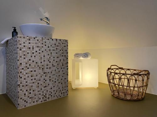 a bathroom with a sink and a basket at Loft im Turm in Maishofen