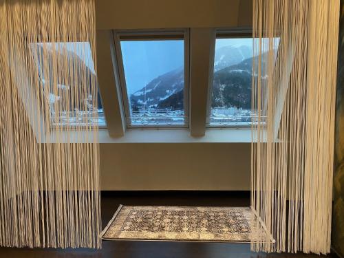 a room with two windows and a rug in front at Loft im Turm in Maishofen