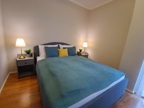a bedroom with a bed with blue and yellow pillows at F151 Elitehost Futó Apartment in Budapest