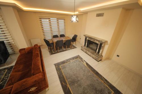 ein Wohnzimmer mit einem Tisch und einem Kamin in der Unterkunft GREEN PEARL VİLLA in Fatsa