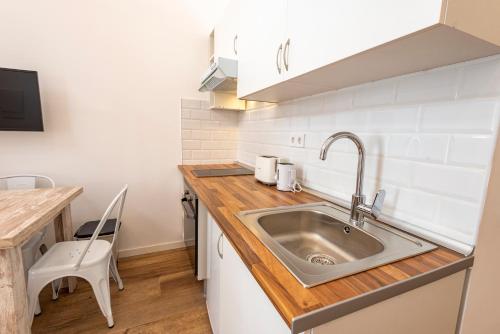 a kitchen with a sink and a wooden counter top at Madrid centro, cálido nuevo, wifi, lava y secarropas in Madrid