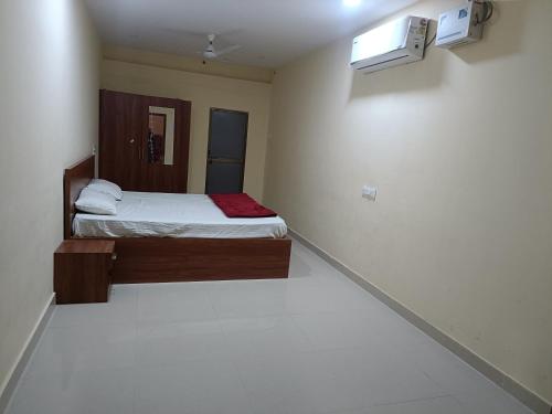Cette petite chambre comprend un lit et une fenêtre. dans l'établissement OM KALYAN MANDAP, à Balāngīr