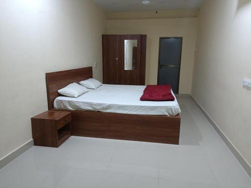 - une chambre avec un lit et une couverture rouge dans l'établissement OM KALYAN MANDAP, à Balāngīr