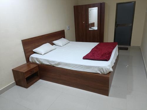- une chambre avec un grand lit et un cadre en bois dans l'établissement OM KALYAN MANDAP, à Balāngīr