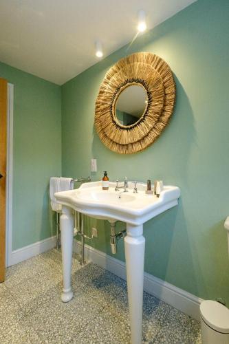 a bathroom with a sink and a mirror at Coastguards in Aldeburgh