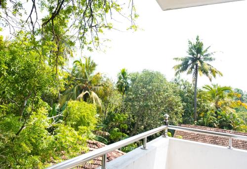 a balcony of a house with trees in the background at Nalaka Relaxing Home in Weligama