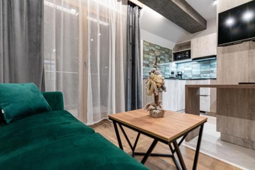 a living room with a green couch and a table at Willa Trawers in Zakopane