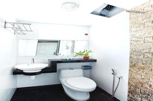 a white bathroom with a toilet and a sink at OYO 90855 Vince Villa in Bukit Mertajam