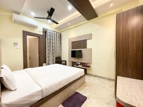 um quarto de hotel com uma cama e uma televisão em Hotel Nandini Palace ! Varanasi ! ! fully-Air-Conditioned-hotel family-friendly-hotel, near-Kashi-Vishwanath-Temple and Ganga ghat em Varanasi