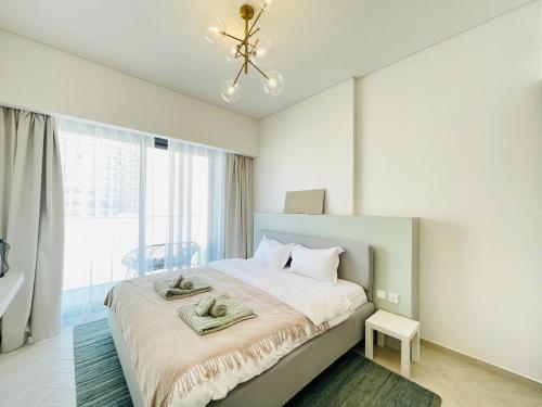 a bedroom with a bed with two towels on it at Brand New Luxury 1 Bedroom Apartment in Dubai