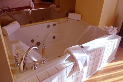 a bath tub in a bathroom with a sink at Hotel Alila in Saint-Sauveur-des-Monts