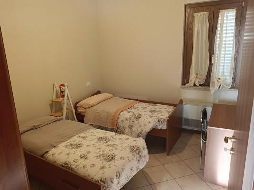 1 dormitorio con 2 camas y ventana en Residence Epizephyri, en Locri