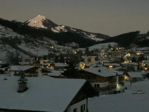 a small town with a snow covered mountain at night at Nicky apartments and studios in Niederau