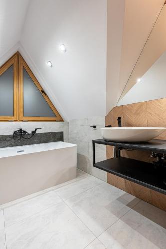 a bathroom with a sink and a bath tub at Willa Trawers in Zakopane