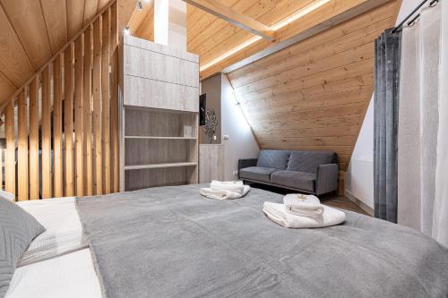 a bedroom with a large bed with towels on it at Willa Trawers in Zakopane
