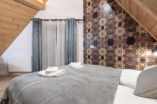 a bedroom with a large bed with towels on it at Willa Trawers in Zakopane