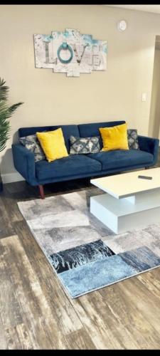 uma sala de estar com um sofá azul e almofadas amarelas em Beautiful And Comfortable 2br 2bath em Chandler